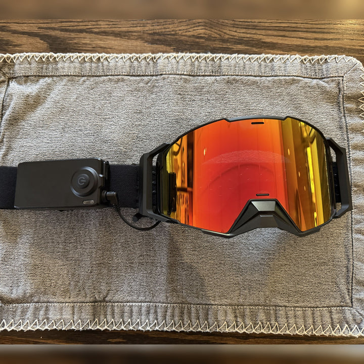 Hillarie heated snowmobile goggle laid flat with the battery pack on the strap #strap_top-secret-1